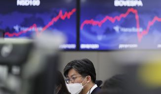A currency trader watches computer monitors at the foreign exchange dealing room in Seoul, South Korea, Wednesday, Dec. 23, 2020. Asian stock markets rose Wednesday after President Donald Trump suggested he may veto a $900 billion economic aid package. (AP Photo/Lee Jin-man)