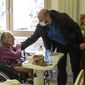 Marguerite Mouille, left, is greeted by her grandson Thierry Mouille at a nursing home in Kaysesberg, eastern France, Monday Dec. 21, 2020. Thierry Mouille is torturing himself over the government&#x27;s Christmas offer of a three-week window of relaxed rules. He&#x27;s changed his mind again and again about whether to bring his 94-year-old grandmother Marguerite out to share a holiday meal. (AP Photo/Jean-Francois Badias)