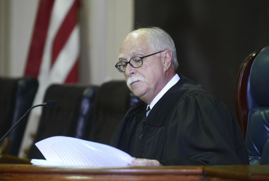 In this 2016 photo, Muskingum County Common Pleas Judge Mark C. Fleegle reads during a court proceeding in Zanesville, Ohio. In December 2020, Fleegle, who failed to adopt written rules for mask wearing and other coronavirus prevention measures, has been barred from overseeing two upcoming trials. His lack of written procedures makes it difficult for jurors and others to know what&#39;s expected of them, Ohio Supreme Court Chief Justice Maureen O&#39;Connor said in an order. (Chris Crook/Times Recorder via AP)