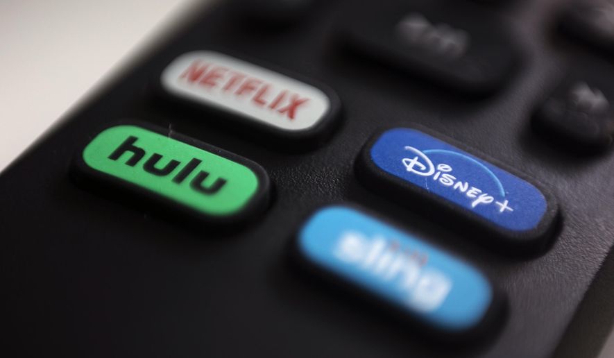In this Aug. 13, 2020 file photo, the logos for Netflix, Hulu, Disney Plus and Sling TV are pictured on a remote control in Portland, Ore. The Hollywood Reporter reported on Monday that the 16th season of Fox’s animated sitcom now jumps from episode 11 to 13 for viewers of the Disney+ streaming service in Hong Kong. Episode 12 depicts the Simpsons family journeying to China, where they encounter in Tiananmen Square a sign that reads: “On this site, in 1989, nothing happened.” (AP Photo/Jenny Kane)