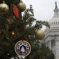 A small tree has been decorated for the Christmas holiday, with the U.S. Capitol seen behind it, Thursday, Dec. 24, 2020, in Washington. (AP Photo/Jacquelyn Martin)