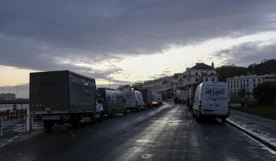 General view of the queue of trucks in the area outside the Port of Dover waiting for a ferry as police block the entrance to the Port of Dover, in Dover, England, Wednesday, Dec. 23, 2020. Freight from Britain and passengers with a negative coronavirus test have begun arriving on French shores, after France relaxed a two-day blockade over a new virus variant. The blockade had isolated Britain, stranded thousands of drivers and raised fears of shortages. (AP Photo/Alberto Pezzali)
