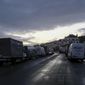 General view of the queue of trucks in the area outside the Port of Dover waiting for a ferry as police block the entrance to the Port of Dover, in Dover, England, Wednesday, Dec. 23, 2020. Freight from Britain and passengers with a negative coronavirus test have begun arriving on French shores, after France relaxed a two-day blockade over a new virus variant. The blockade had isolated Britain, stranded thousands of drivers and raised fears of shortages. (AP Photo/Alberto Pezzali)