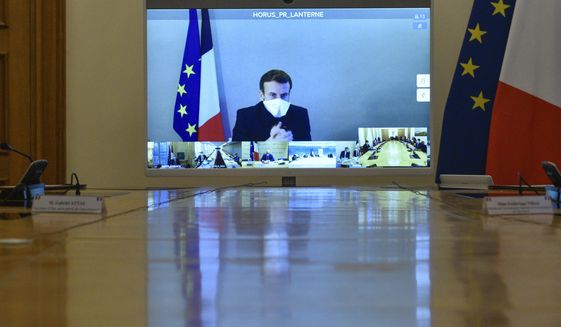 French President Emmanuel Macron is seen on a screen from his presidential residence in Versailles as he attends by video conference the weekly cabinet meeting at the Elysee Palace in Paris, Monday, Dec. 21, 2020. French President Emmanuel Macron held a cabinet meeting Monday via video, in which he indicated the French could enforce &amp;quot;systematic tests&amp;quot; as a condition for French nationals returning from Britain to France for the holidays. (Julien de Rosa/Pool Photo via AP)
