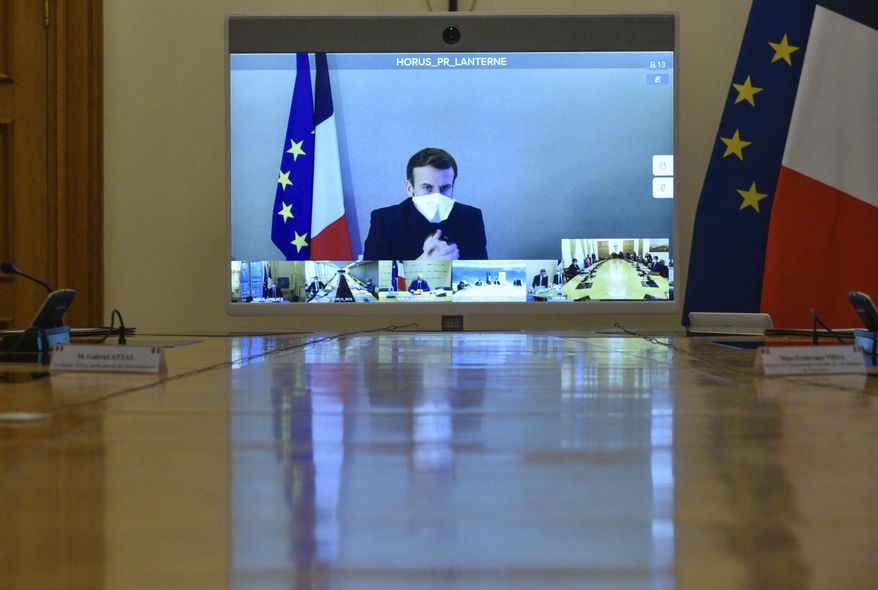 French President Emmanuel Macron is seen on a screen from his presidential residence in Versailles as he attends by video conference the weekly cabinet meeting at the Elysee Palace in Paris, Monday, Dec. 21, 2020. French President Emmanuel Macron held a cabinet meeting Monday via video, in which he indicated the French could enforce &amp;quot;systematic tests&amp;quot; as a condition for French nationals returning from Britain to France for the holidays. (Julien de Rosa/Pool Photo via AP)