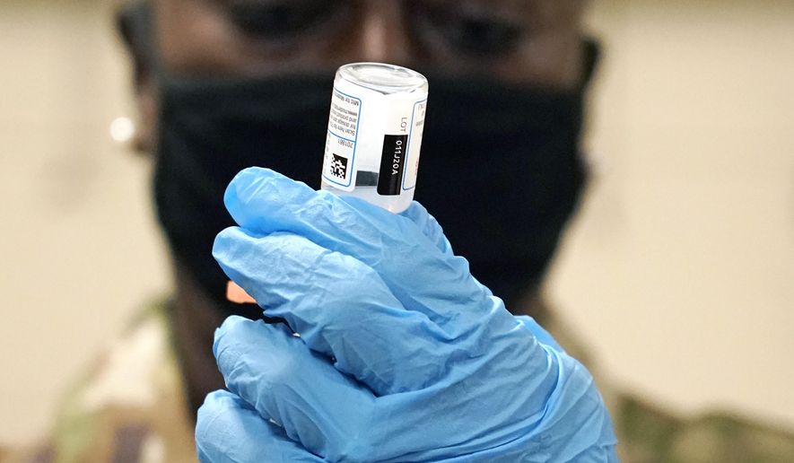 Mississippi Air Guard Tech. Sgt. Exstrella Smith withdraws a dose of the Moderna COVID-19 vaccine for injection into the arm of a Mississippi Air or Army National Guard service member who serves as a first responder, Wednesday, Dec. 23, 2020, in Flowood, Miss. One hundred doses of the vaccine were administered to both Mississippi Air and Army National Guard service members who currently assist with the administering of the COVID-19 test at Mississippi Department of Health drive through community testing sites across the state. (AP Photo/Rogelio V. Solis)