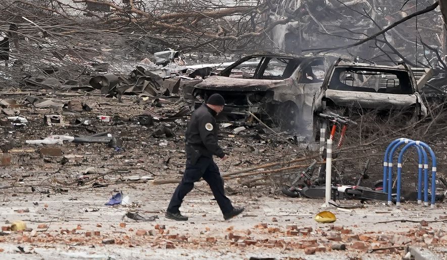 A law enforcement member walks past damage from an explosion in downtown Nashville, Tenn., Friday, Dec. 25, 2020. Buildings shook in the immediate area and beyond after a loud boom was heard early Christmas morning. (AP Photo/Mark Humphrey)