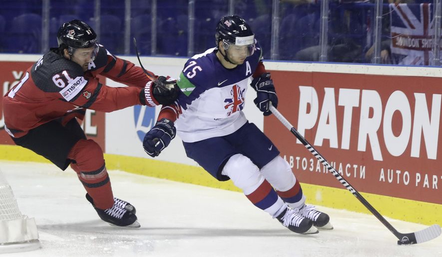 FILE - In this Sunday, May 12, 2019 file photo, Canada&#39;s Mark Stone, left, challenges Great Britain&#39;s Robert Dowd during the Ice Hockey World Championships group A match between Great Britain and Canada at the Steel Arena in Kosice, Slovakia. Ice hockey in Britain had been on a roll before the coronavirus. The Elite Ice Hockey League attendance was up. The national team broke into the top level of the world championship alongside the likes of Sweden, Russia and Canada. (AP Photo/Petr David Josek, File)