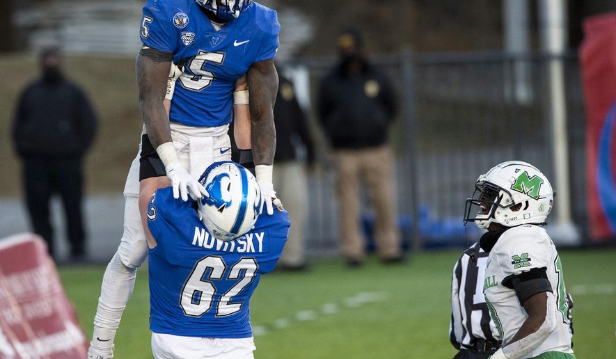 Buffalo running back Kevin Marks, Jr. (5) is lifted in celebration by teammate Mike Novitsky after scoring the game-winning touchdown against Marshall during the Camellia Bowl NCAA college football game Friday, Dec. 25, 2020, in Montgomery, Ala. (Jake Crandall/The Montgomery Advertiser via AP)