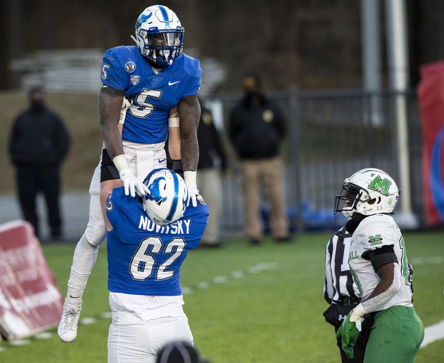 Buffalo running back Kevin Marks, Jr. (5) is lifted in celebration by teammate Mike Novitsky after scoring the game-winning touchdown against Marshall during the Camellia Bowl NCAA college football game Friday, Dec. 25, 2020, in Montgomery, Ala. (Jake Crandall/The Montgomery Advertiser via AP)