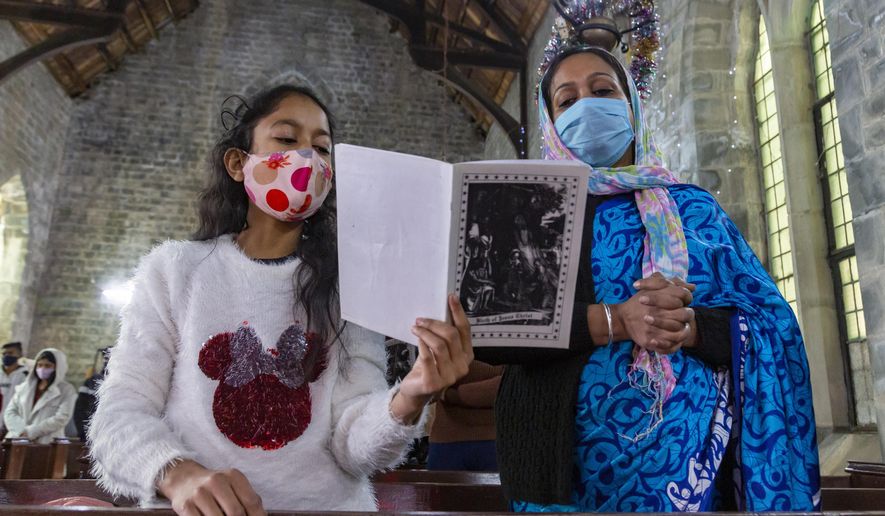Indian Christians, who are registered members of St. John in the Wilderness church, attend the Christmas mass in Dharmsala, India, Friday, Dec. 25, 2020. The church which was built in 1852, is currently closed to general visitors due to COVID-19 restrictions. (AP Photo/Ashwini Bhatia)