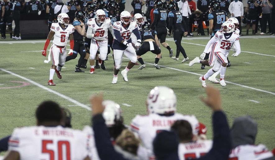 Liberty players celebrate after defeating Coastal Carolina in overtime with a blocked field goal in the Cure Bowl NCAA college football game Saturday, Dec. 26, 2020, in Orlando, Fla. (AP Photo/Matt Stamey)