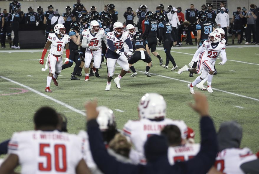 Liberty players celebrate after defeating Coastal Carolina in overtime with a blocked field goal in the Cure Bowl NCAA college football game Saturday, Dec. 26, 2020, in Orlando, Fla. (AP Photo/Matt Stamey)