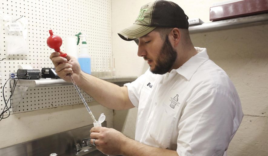 Erik Maselkevich tests products daily at the Milkhouse Creamery in Drums, Pa., Nov. 17, 2020. The company has been managing to expand and adapt during the pandemic. They purchase milk from the Bloss Farm in Wapwallopen and bottle it in their facility in Drums. (Warren Ruda/Standard-Speaker via AP)