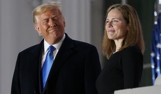 FILE - In this Monday, Oct. 26, 2020 file photo, President Donald Trump and Amy Coney Barrett stand on the Blue Room Balcony after Supreme Court Justice Clarence Thomas administered the Constitutional Oath to her on the South Lawn of the White House White House in Washington. President Donald Trump’s deep imprint on the federal courts is a rare point of agreement about the president across the political spectrum. With a major assist from Senate Majority Leader Mitch McConnell, Trump and his White House staff relentlessly, almost robotically, filled nearly every opening in the federal judiciary, undeterred by Democratic criticism. (AP Photo/Patrick Semansky, File)