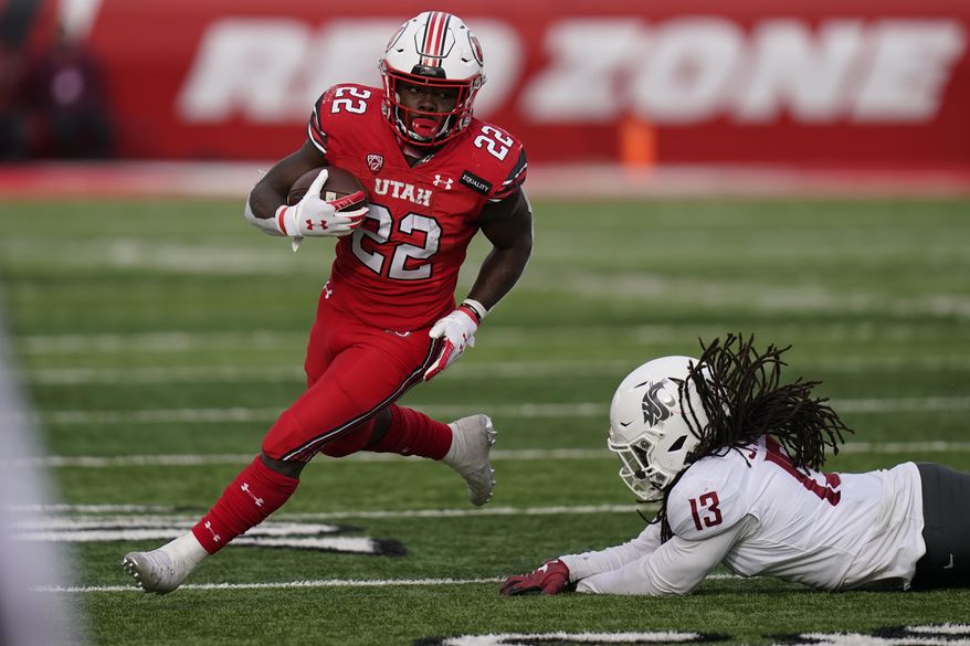 FILE - In this Dec. 19, 2020, file photo, Utah running back Ty Jordan (22) runs for a score as he eludes a tackle by Washington State linebacker Jahad Woods (13) during the second half of an NCAA college football game, in Salt Lake City. Jordan, a star freshman running back for the University of Utah who grew up in the Dallas area, has died, school officials announced Saturday, Dec. 26. Authorities in Texas and Utah have not released details about the circumstances of the Jordan's death. (AP Photo/Rick Bowmer, File)