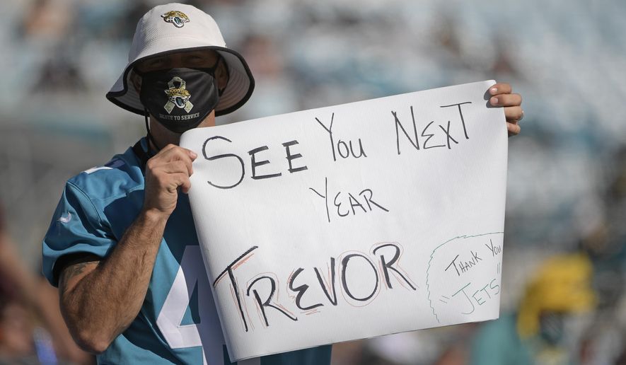 A Jacksonville Jaguars fan hold up a sign hoping that Clemson quarterback Trevor Lawerence will be the first pick for the Jacksonville Jaguars during the second half of an NFL football game against the Chicago Bears, Sunday, Dec. 27, 2020, in Jacksonville, Fla. (AP Photo/Phelan M. Ebenhack)
