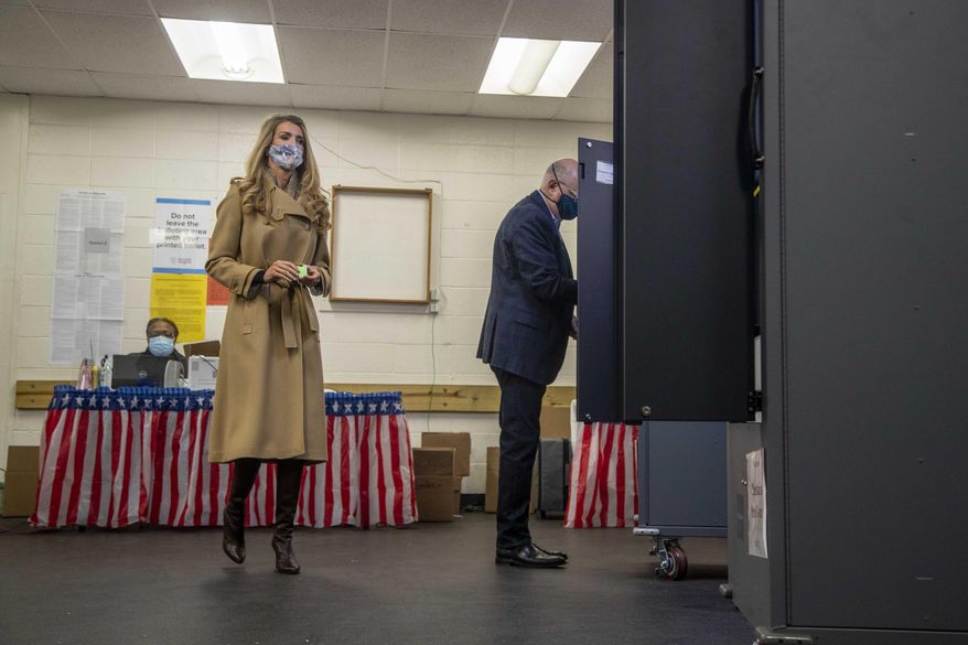 U.S. Sen. Kelly Loeffler, R-Ga., prepares to cast her ballot alongside her husband, Jeff Sprecher, right, during early voting in runoff elections at Chastain Park Gymnasium in Atlanta's Chastain Park neighborhood, Wednesday, Dec. 16, 2020. (Alyssa Pointer/Atlanta Journal-Constitution via AP) **FILE**