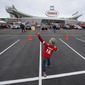 Nine-year-old Hudson Henry plays catch while tailgating in the parking lot at Arrowhead stadium before an NFL football game between the Atlanta Falcons and the Kansas City Chiefs Sunday, Dec. 27, 2020, in Kansas City, Mo. (AP Photo/Charlie Riedel)