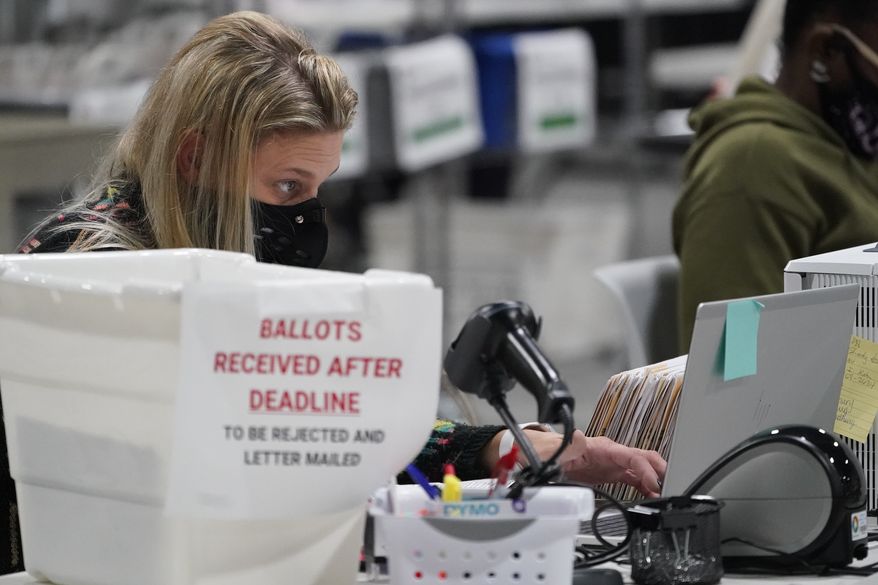 FILE - In this Friday, Nov. 6, 2020, file photo, officials work on ballots at the Gwinnett County Voter Registration and Elections headquarters, in Lawrenceville, near Atlanta. (AP Photo/John Bazemore, File)