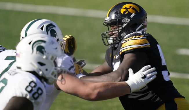Iowa defensive tackle Daviyon Nixon, right, rushes up field during the second half of an NCAA college football game against Michigan State, Saturday, Nov. 7, 2020, in Iowa City, Iowa. Nixon was selected to The Associated Press All-America first-team defense, Monday, Dec. 28, 2020. (AP Photo/Charlie Neibergall)