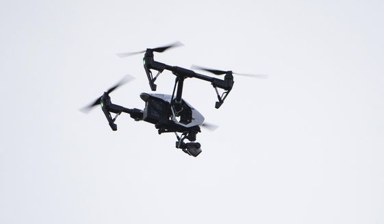 FILE - In this Thursday, Aug. 8, 2019, file photo, a drone flies in a residential neighborhood in Upper Moreland, Pa. Federal officials are outlining new rules that will let operators fly small drones over people and at night. (AP Photo/Matt Rourke, File)