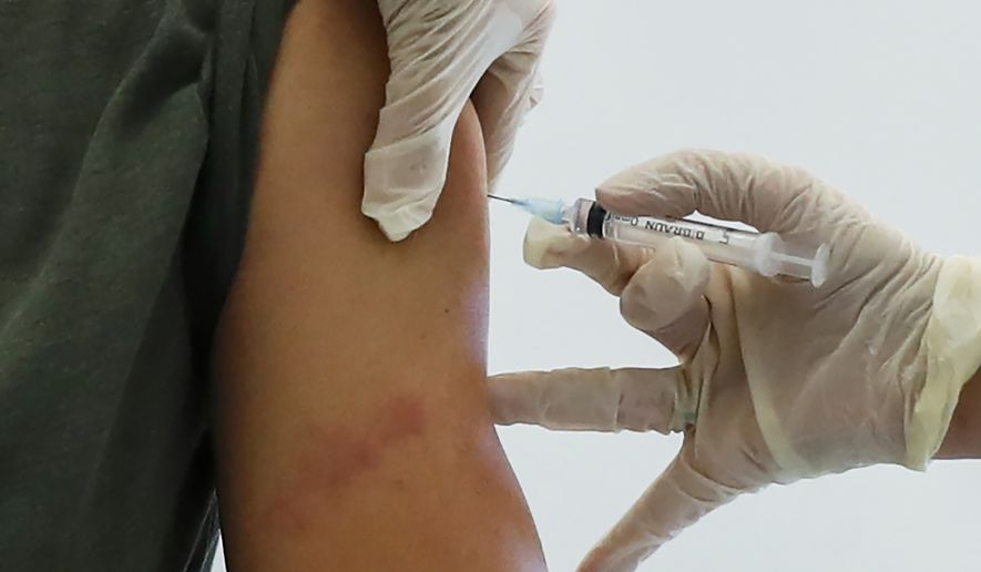 In this file photo dated Saturday, Dec. 5, 2020, a Russian medical worker administers a shot of Russia&#39;s Sputnik V coronavirus vaccine in Moscow, Russia. Belarus on Tuesday, Dec. 29, 2020, has announced the start of mass coronavirus vaccinations with the Russian-developed Sputnik V shot, becoming the second country after Russia to roll out the vaccine. (AP Photo/Pavel Golovkin, FILE)