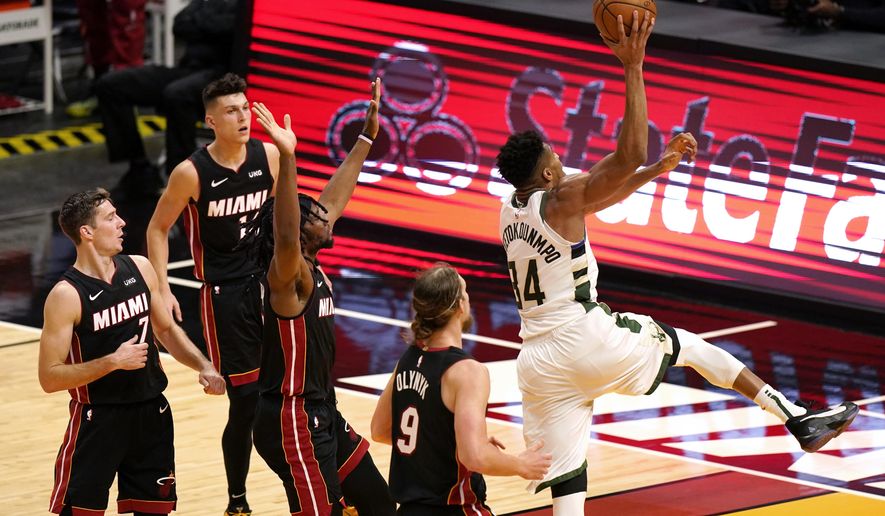 Milwaukee Bucks forward Giannis Antetokounmpo (34) shoots next to Miami Heat forward Kelly Olynyk (9) during the first half of an NBA basketball game Tuesday, Dec. 29, 2020, in Miami. (AP Photo/Lynne Sladky)