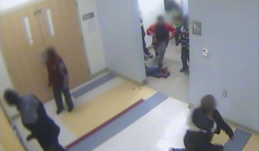 FILE - In this file still image from a Jan. 24, 2017, surveillance video provided by Cincinnati Public Schools, the legs and feet of 8-year-old Gabriel Taye can be seen as he lies on the floor of a boys' bathroom after being knocked unconscious by another boy at Carson Elementary School. Two days later, Taye hanged himself with a necktie in the bedroom of his Cincinnati apartment. Taye's parents can move forward with a lawsuit against the Cincinnati school district that alleges wrongful death and other charges, a federal appeals panel ruled Tuesday, Dec. 29, 2020. (Cincinnati Public Schools via AP, File)
