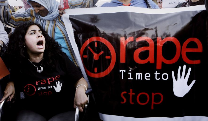 FILE - In this June 14, 2014 file photo, Egyptian women shout slogans and hold banners during a protest against sexual assaults, in Cairo, Egypt. On Tuesday, Dec. 29, 2020, an Egyptian court convicted a former student at an elite university on sexual misconduct charges and sentenced him to three years in prison, the first conviction in a case that has fueled the #MeToo movement in the Arab world’s most populous country. (AP Photo/Amr Nabil, File)