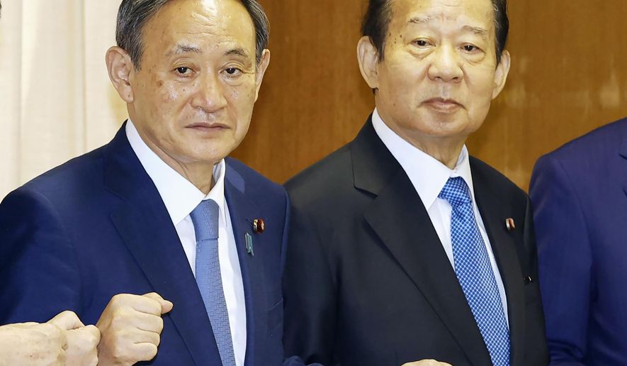 Japanese Prime Minister Yoshihide Suga, left, also the Liberal Democratic Party party leader, poses with the ruling party&#39;s senior officials, including Toshihiro Nikai, right, at the party headquarters in Tokyo, on Sept. 15, 2020. Prime Minister Suga came to office on a surge of popularity, pledging to combat the coronavirus and fix the languishing economy. Now his support ratings have plunged amid flaring virus outbreaks and scandals within the ruling party, even as the economy appears to be recovering. (Kyodo News via AP)