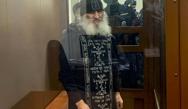 In this handout photo released by Basmanny Court via Moscow News Agency, Father Sergiy, a Russian monk who has defied the Russian Orthodox Church&#x27;s leadership, stands in a cage prior to a court session in Moscow, Russia, Tuesday, Dec. 29, 2020.  Father Sergiy, who has castigated the Kremlin and the Russian Orthodox Church leadership and denied the coronavirus existence, was detained Tuesday Dec. 29, 2020, by police at a monastery in the Urals and flown to Moscow where he will face criminal charges. (Basmanny Court, Moscow News Agency photo via AP)
