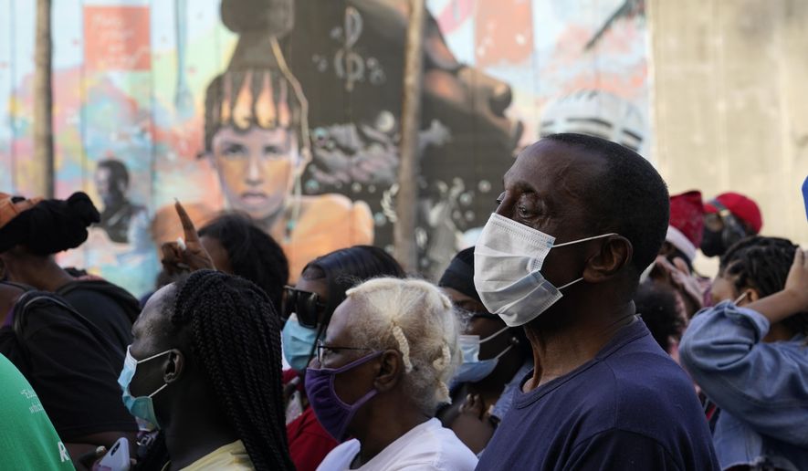 Residents in the Overtown neighborhood of Miami wait in line to receive gift cards and gift bags with essentials, Tuesday, Dec. 29, 2020. Various organizations came together to distribute items to those in need during the coronavirus pandemic. Rapper Sean "Diddy" Combs also passed out fifty dollar bills to residents. (AP Photo/Lynne Sladky)