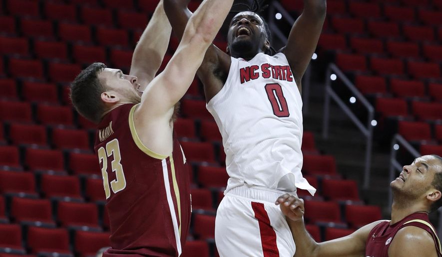 North Carolina State's D.J. Funderburk (0) shoots as Boston College's James Karnik (33) defends during the first half of an NCAA college basketball game in Raleigh, N.C., Wednesday, Dec. 30, 2020. (Ethan Hyman/The News & Observer via AP, Pool)