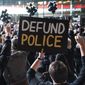 In this Wednesday, Oct. 14, 2020, file photo, a protester holds a sign that reads &#39;Defund Police&#39;during a rally for the late George Floyd outside Barclays Center, in New York. (AP Photo/John Minchillo, File)  **FILE**