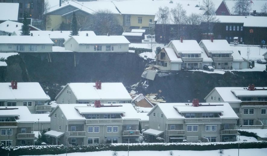 Some houses remain standing while others are seen damaged after a landslide occurred in a residential area in Ask, near Oslo, Wednesday, Dec. 30, 2020. Several houses have been destroyed, up to 200 people have been evacuated and nine injured in Norway in a landslide at a residential area near the capital Oslo. Norwegian police were alarmed around 4 am Wednesday that a landslide had occured in the village of Ask in the municipality of Gjerdrum, some thirty kilometers (12 miles) north of Oslo. (Fredrik Hagen/NTB via AP)