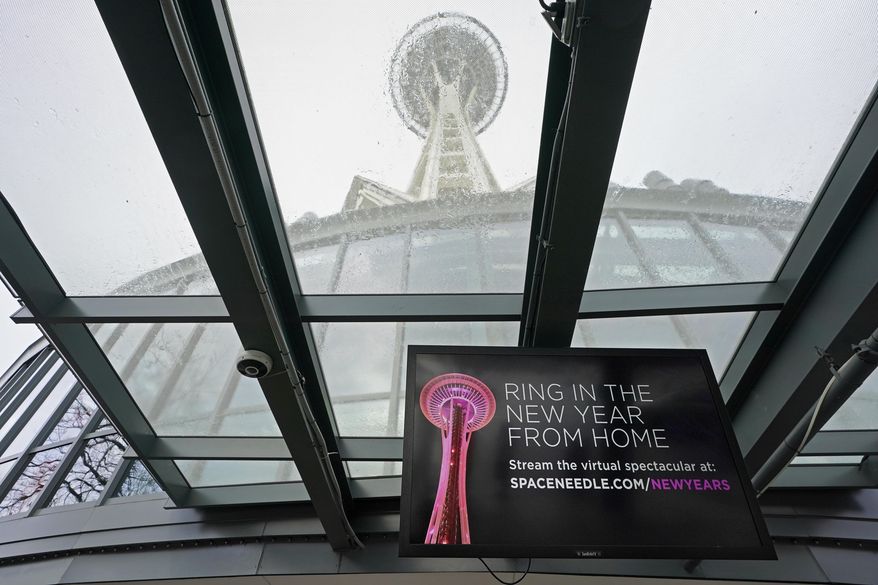 A video display at Space Needle tells visitors that the landmark's usual in-person fireworks display on New Year's Eve will instead be a virtual display streamed on the internet, Wednesday, Dec. 30, 2020, in Seattle. The coronavirus scourge that dominated the 2020 is also looming over New Year's festivities and forcing officials worldwide to tone them down. From New York's Times Square to Sydney Harbor, big public blowouts are being turned into TV-only shows and digital events. (AP Photo/Ted S. Warren)