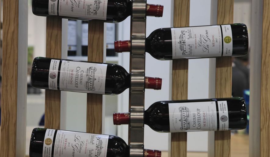 FILE - In this Feb.10, 2020 file photo, red wine bottles of the region of Medoc, western France, are displayed at the wine fair in Paris. French wine exporters are warning that they'll take a billion-euro hit in 2021 from the latest ratcheting-up of punitive tariffs between the United States and Europe in a trade row over aircraft subsidies. (AP Photo/Michel Euler, File)