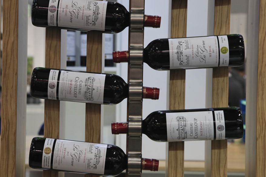 FILE - In this Feb.10, 2020 file photo, red wine bottles of the region of Medoc, western France, are displayed at the wine fair in Paris. French wine exporters are warning that they'll take a billion-euro hit in 2021 from the latest ratcheting-up of punitive tariffs between the United States and Europe in a trade row over aircraft subsidies. (AP Photo/Michel Euler, File)