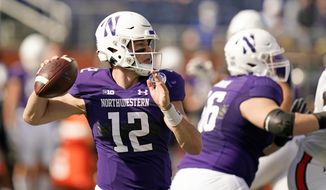 Northwestern quarterback Peyton Ramsey (12) looks for a receiver against Auburn during the first half of the Citrus Bowl NCAA college football game, Friday, Jan. 1, 2021, in Orlando, Fla. (AP Photo/John Raoux)