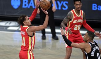 Atlanta Hawks guard Trae Young (11) shoots over Brooklyn Nets guard Timothe Luwawu-Cabarrot (9) during the first half of an NBA basketball game Friday, Jan. 1, 2021, in New York. (AP Photo/Adam Hunger)