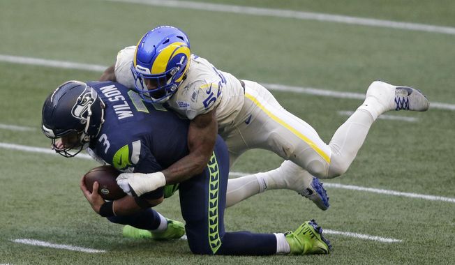 Seattle Seahawks quarterback Russell Wilson (3) is sacked by Los Angeles Rams outside linebacker Leonard Floyd (54) during the first half of an NFL football game, Sunday, Dec. 27, 2020, in Seattle. (AP Photo/Scott Eklund)