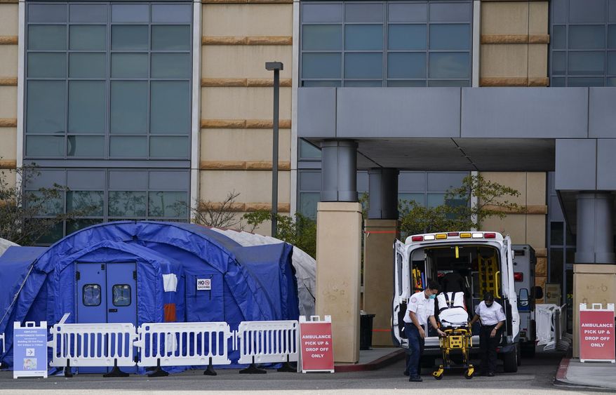 FILE - In this Dec. 17, 2020, file photo, medical workers remove a stretcher from an ambulance near medical tents outside the emergency room at UCI Medical Center, in Irvine, Calif. After months spent tamping down surges and keeping the coronavirus at manageable levels, a variety of factors combined to bring California to a crisis point in the pandemic. (AP Photo/Ashley Landis, File)