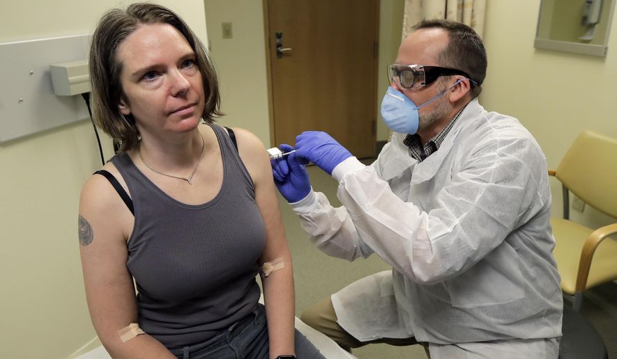 FILE - In this March 16, 2020 file photo, a pharmacist gives Jennifer Haller, left, the first shot in the first-stage safety study clinical trial of a potential vaccine for COVID-19, the disease caused by the new coronavirus, at the Kaiser Permanente Washington Health Research Institute in Seattle. Tens of thousands of Americans have volunteered to test COVID-19 vaccines, but only about half of them got the real thing. Now, with the first vaccine rollouts and a surge in coronavirus infections, experts are debating what to do about the half that got a dummy shot. (AP Photo/Ted S. Warren, File)