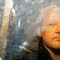 In this Wednesday May 1, 2019 file photo, buildings are reflected in the window as WikiLeaks founder Julian Assange is taken from court, where he appeared on charges of jumping British bail seven years ago, in London. (AP Photo/Matt Dunham, File)