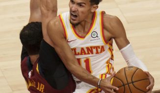 Atlanta Hawks guard Trae Young (11) drives past Cleveland Cavaliers forward Larry Nance Jr. (22) during the first half of an NBA basketball game on Saturday, Jan. 2, 2021 in Atlanta. (AP Photo/Ben Gray)