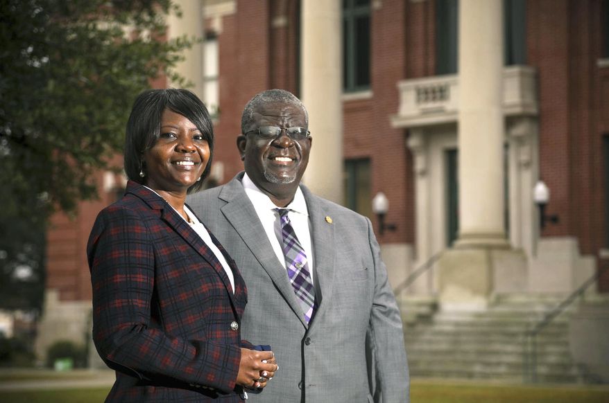 Kevin L. Johnson, a South Carolina Senator, poses with his daughter, Kimberly O. Johnson, a newly elected member of the S.C. House of Representatives, in front of the Manning Courthouse where they live in Manning, S.C., on Thursday, Dec. 17, 2020. (Tracy Glantz/The State via AP)