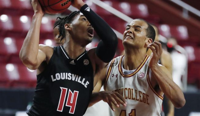 Louisville&#x27;s Dre Davis (14) shoots against Boston College&#x27;s Steffon Mitchell (41) during the first half of an NCAA college basketball game, Saturday, Jan. 2, 2021, in Boston. (AP Photo/Michael Dwyer)