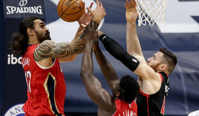 New Orleans Pelicans center Steven Adams (12), forward Zion Williamson (1) and Toronto Raptors center Aron Baynes (46) fight for a rebound during the first half of an NBA basketball game on Saturday, Jan. 2, 2021, in New Orleans. (AP Photo/Butch Dill)