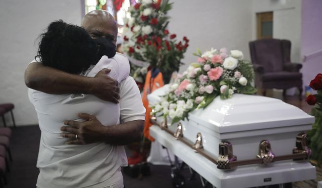 FILE - In this July 21, 2020, file photo, Darryl Hutchinson, facing camera, is hugged by a relative during a funeral service for Lydia Nunez, who was Hutchinson&#x27;s cousin at the Metropolitan Baptist Church in Los Angeles. Nunez died from COVID-19. Southern California funeral homes are turning away bereaved families because they&#x27;re running out of space for the bodies piling up during an unrelenting coronavirus surge. (AP Photo/Marcio Jose Sanchez, File)